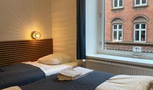 een slaapkamer met een bed voor een raam bij Milling Hotel Mini 11 in Odense