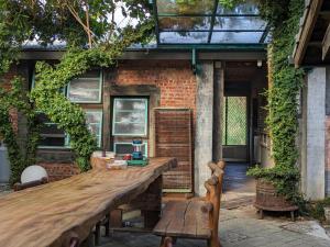 a wooden table in front of a brick building at 都蘭小星民宿 Dulan Star Guest House in Donghe