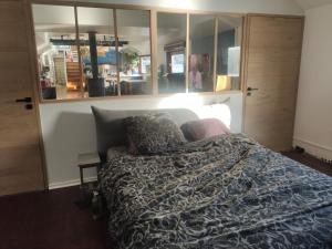 a bedroom with a bed and some glass cabinets at Experience Paris 2024 from la Seine in Villeneuve-la-Garenne