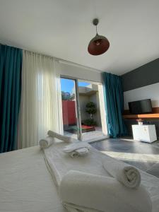 a bedroom with a large bed with blue curtains at SEREN OTEL ÇEŞME in Cesme