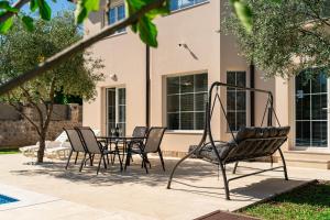 een groep stoelen en een tafel voor een gebouw bij Villa Stemi in Tivat