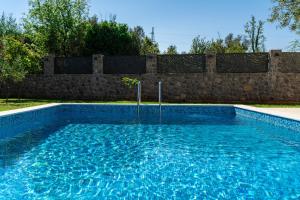 a swimming pool in front of a stone wall at Villa Stemi in Tivat