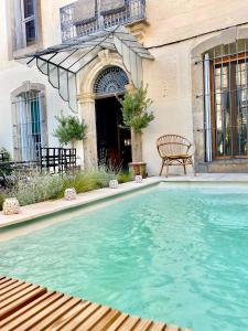 una piscina frente a una casa con un banco en Le Jardin, en Aspiran