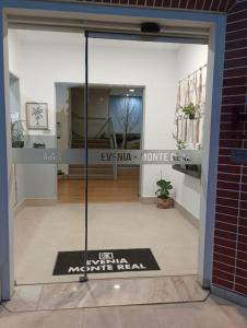 Una puerta de cristal de una tienda con un cartel. en Evenia Monte Real, en Monte Real