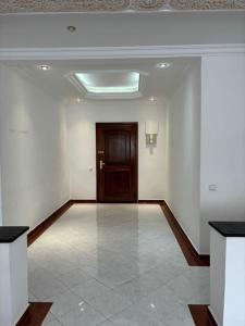 una stanza vuota con una porta e un pavimento piastrellato di Appartement lumineux et moderne sur Mohammedia a Mohammedia