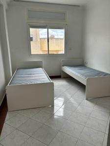 2 letti in una camera con finestra di Appartement lumineux et moderne sur Mohammedia a Mohammedia