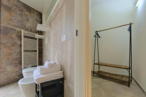 ein Badezimmer mit 2 WCs und einer ebenerdigen Dusche in der Unterkunft Imola Suites - Self Check-in in Imola