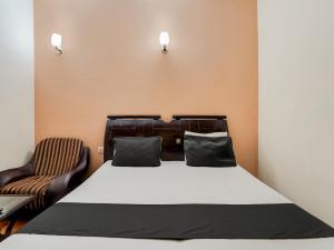a bedroom with a bed and a chair at Super OYO Le Regent in Gurgaon