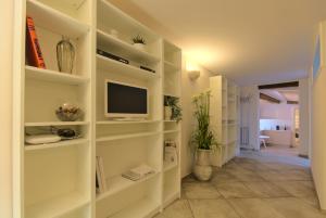ein Wohnzimmer mit weißen Regalen und einem TV in der Unterkunft Imola Suites - Self Check-in in Imola