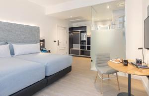 een slaapkamer met een bed, een bureau en een tafel bij INNSiDE by Meliá Madrid Valdebebas in Madrid