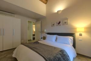 um quarto com uma cama grande e almofadas brancas em Imola Suites - Self Check-in em Imola