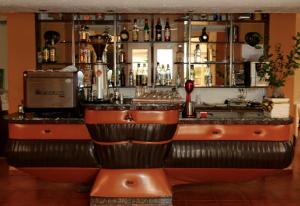 a bar with orange leather seats and a counter at Hotel President in Golem
