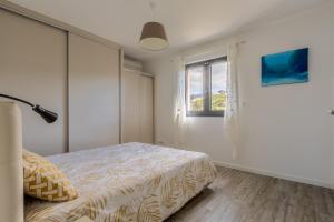 une chambre avec un lit et une fenêtre dans l'établissement Les Terrasses de l'Isolella - Vue mer et montagne, à Pietrosella