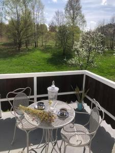 una mesa y sillas en un balcón con mesa y sillas en W Karkonoszach na Chacie #SAUNA # BILARD #LEŚNY PARK, en Wojcieszyce