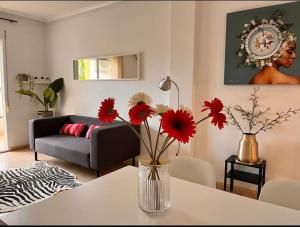 a living room with a vase with red flowers on a table at Casa Rio in Rojales