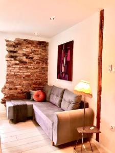 sala de estar con sofá y pared de ladrillo en W Karkonoszach na Chacie #SAUNA # BILARD #LEŚNY PARK, en Wojcieszyce