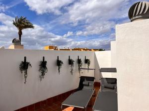 a white wall with chairs and plants on it at Casa Rio in Rojales