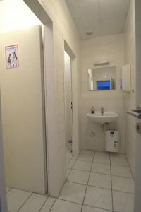 a white bathroom with a sink and a toilet at Frühlings Apartments GL21 in Bergisch Gladbach