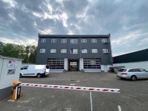 ein großes Gebäude mit Autos auf einem Parkplatz in der Unterkunft Frühlings Apartments GL21 in Bergisch Gladbach