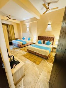 a hotel room with two beds and a couch at Shivjot hotel in Kharar