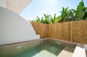 a swimming pool in a backyard with a wooden fence at Atma Beach Rooms & Suites in Faliraki