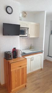 a small kitchen with a counter and a microwave at appartement chaleureux avec terrasse ensoleillée 2 étoiles in Le Mont-Dore