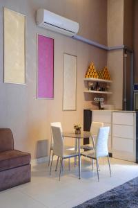 jadalnia ze stołem i białymi krzesłami w obiekcie Liberty Avenue Hotel w mieście Doha