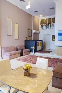 ein Wohnzimmer mit einem Tisch und Stühlen in der Unterkunft Liberty Avenue Hotel in Doha