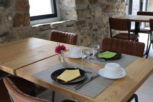 a wooden table with plates and napkins on it at Le Relais de Porz Morvan in Plomodiern