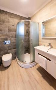 a bathroom with a shower and a toilet and a sink at SEREN OTEL ÇEŞME in Cesme