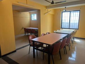 a classroom with tables and chairs in a room at Aishvarya Residency Coimbatore in Coimbatore