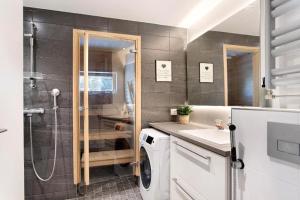 ein Badezimmer mit Dusche und Waschmaschine in der Unterkunft Kolmio Keskuspuiston lähellä in Espoo