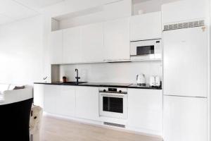 eine weiße Küche mit weißen Schränken und Geräten in der Unterkunft Kolmio Keskuspuiston lähellä in Espoo