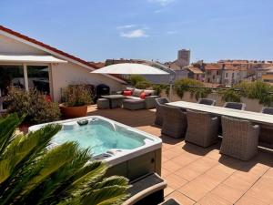 a hot tub sitting on top of a patio at Patio d'Azur toit terrasse haut de gamme 3 ch jacuzzi coeur de ville et plage in Saint-Raphaël