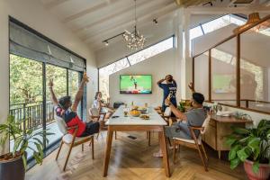 a group of people sitting around a table in a living room at SaffronStays Arabella in Alibaug