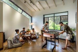 a group of people playing chess in a room at SaffronStays Arabella in Alibaug