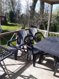 una mesa de picnic y sillas en una terraza en Mobile home S004, en Lancieux
