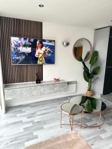 Glam Escape: Lavish Haven في لندن: غرفة معيشة مع تلفزيون على الحائط