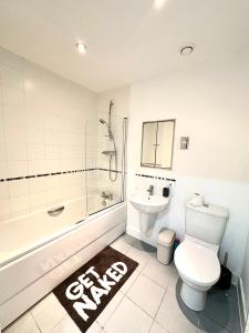 Glam Escape: Lavish Haven في لندن: حمام مع مرحاض وحوض استحمام ومغسلة