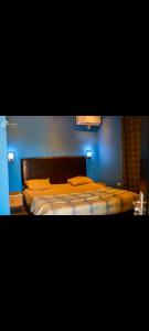 a bedroom with a bed with a blue wall at CIDMAT VILLA in Freetown