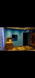 un soggiorno con parete blu e TV di CIDMAT VILLA a Freetown