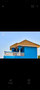 una foto di una casa blu su uno schermo televisivo di CIDMAT VILLA a Freetown