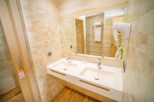 ein Badezimmer mit einem weißen Waschbecken und einem Spiegel in der Unterkunft SV Chrome by AJ Boutique Hotel in Abuja + 40 Fotos