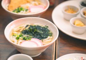 a bowl of food on a table with other dishes at APA Hotel Ueno Ekikita in Tokyo