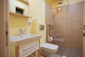 ein Bad mit einem Waschbecken, einem WC und einer Dusche in der Unterkunft Pensiune Agroturistica Molidu in Almaş