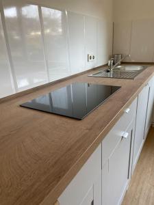 a kitchen with white cabinets and a wooden counter top at Schöne Erdgeschoss-Wohnung in Bremen in Bremen