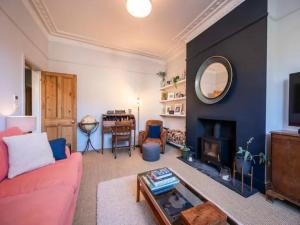 a living room with a red couch and a fireplace at Pass the Keys London Spacious Dulwich family house with Pool in London