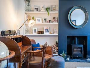 ein Wohnzimmer mit einem Tisch und einem Spiegel in der Unterkunft Pass the Keys London Spacious Dulwich family house with Pool in London