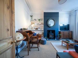 a living room with a table and a mirror at Pass the Keys London Spacious Dulwich family house with Pool in London