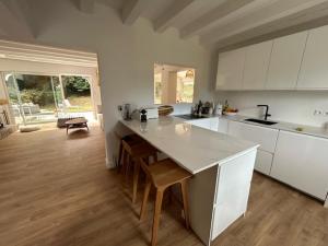 a kitchen with white cabinets and a table with chairs at Magnifique Villa proche Golf & Centre d' Hossegor avec Jacuzzi in Capbreton